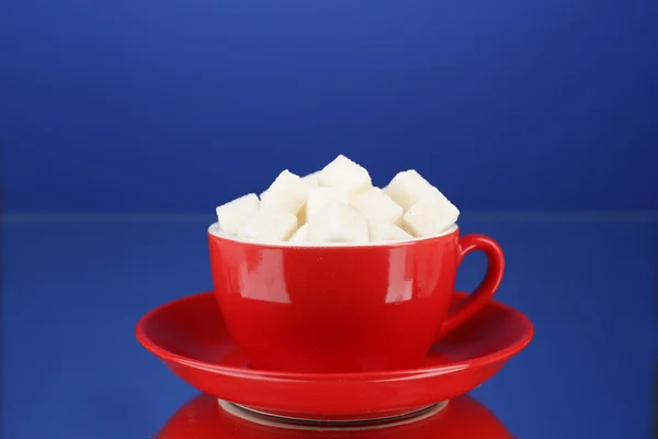 Sugar in cup on blue background — Stock Photo, Image