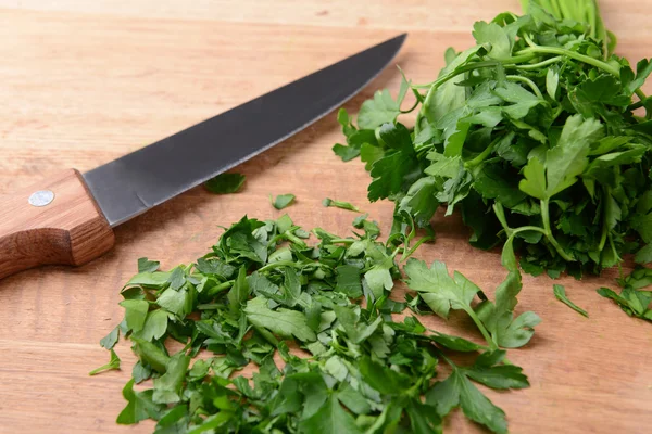 Chopped parsley on wooden board close-up — Stock Photo, Image