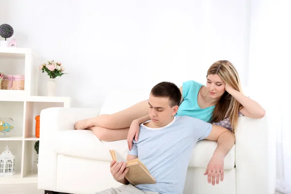 Beautiful couple reading on sofa — Stock Photo, Image