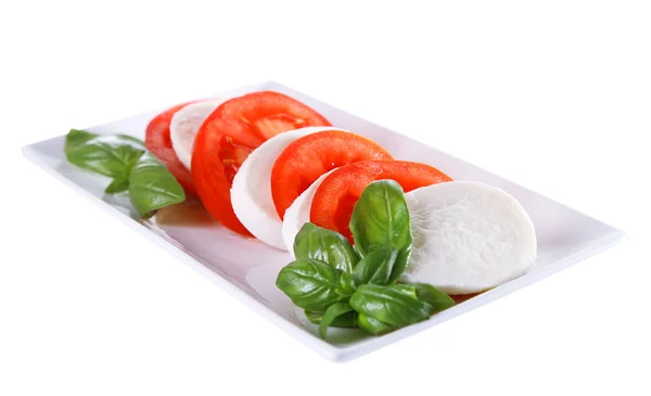 Ensalada Caprese con queso mozarella, tomates y albahaca en plato, aislada sobre blanco —  Fotos de Stock