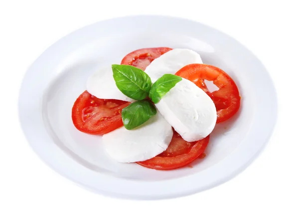 Салат капрезе с сыром мозарелла, помидорами и базиликом на тарелке, изолированный на белом — стоковое фото