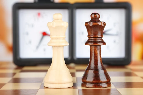 Tablero de ajedrez con ajedrez y reloj sobre fondo claro —  Fotos de Stock