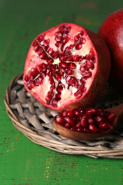 Ripe pomegranates on color wooden background — Stock Photo, Image