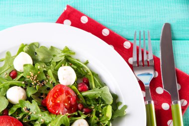 roka, domates, peynir mozzarella toplar ve plaka renk ahşap zemin üzerine susam ile yapılan yeşil salata