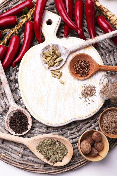 Diferentes especias con tabla de cortar en blanco, de cerca — Foto de Stock