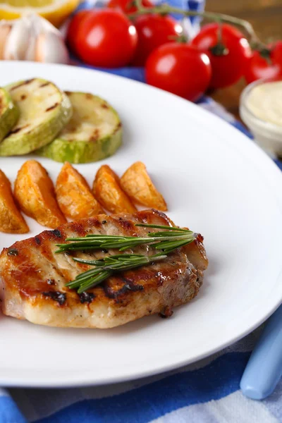 Grilled steak, grilled vegetables and fried potato pieces on table background — Stock Photo, Image