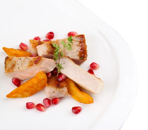 Grillat kött med stekt potatis bitar och granatäpplekärnor på plattan, isolerad på vit — Stockfoto