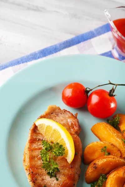 Filete a la parrilla, verduras a la parrilla y patatas fritas en la mesa, sobre un fondo brillante — Foto de Stock