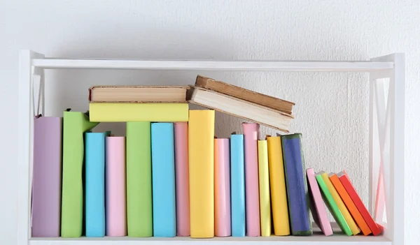 Boeken over witte plank in de kamer — Stockfoto