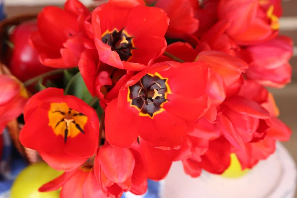 Buquê de tulipas coloridas em cesta de vime, na cadeira, close-up — Fotografia de Stock