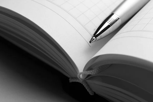 Pen on opened book on grey table, close up — Stock Photo, Image