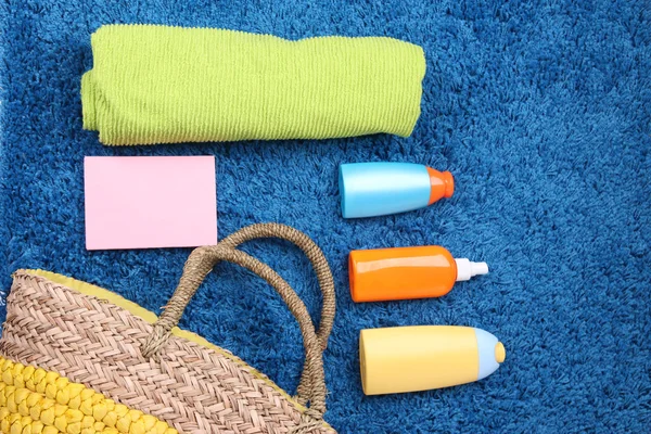 Wicker bag, swimsuit, bottles with lotions on color background. — Stock Photo, Image