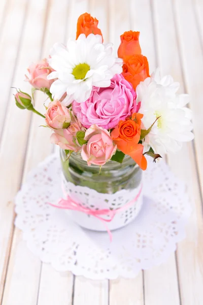 Beautiful bouquet of bright flowers in jars on table close-up — Stock Photo, Image