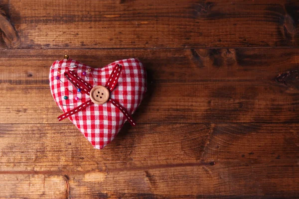 Corazón de tela con alfileres de color sobre fondo de madera —  Fotos de Stock