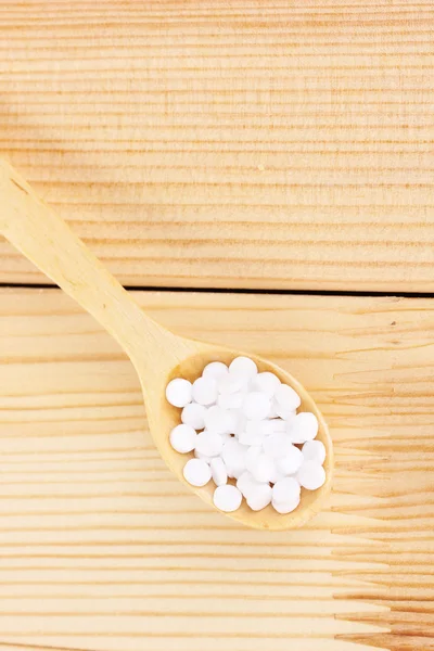 Sweetener in spoon on wooden background — Stock Photo, Image