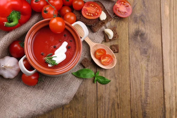 Sopa de tomate saborosa e legumes na mesa de madeira — Fotografia de Stock