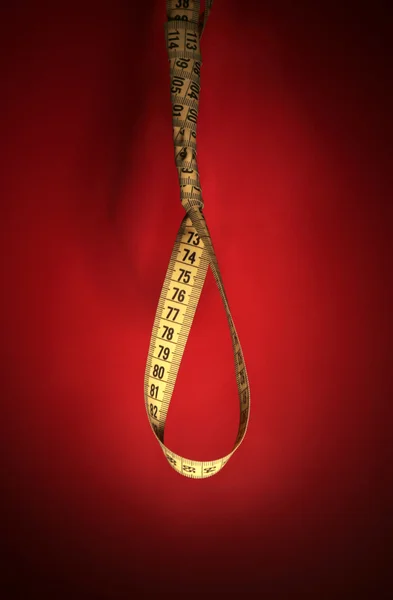 Tape measure noose on red background - diet concept — Stock Photo, Image