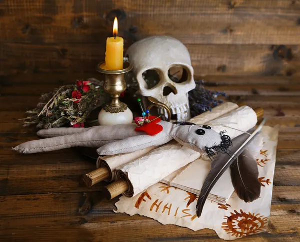 Conceptual photo of love magic. Composition with skull, voodoo doll, dried herbs and candle on  dark wooden background — Stock Photo, Image