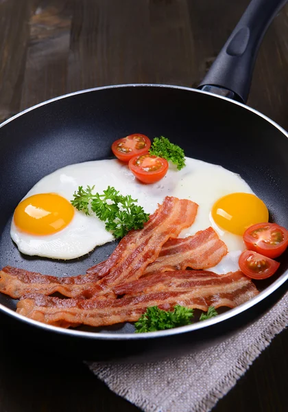 Míchaná vejce a slaninu na pánvi na tabulka detail — Stock fotografie