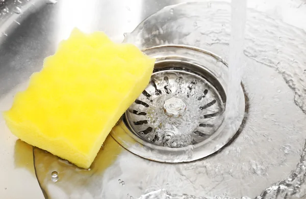 Water flowing down hole in kitchen sink — Stock Photo, Image