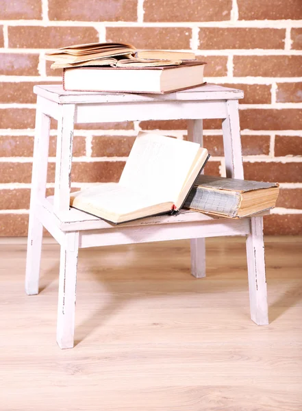 Livros em escada de madeira sobre fundo de parede de cor — Fotografia de Stock