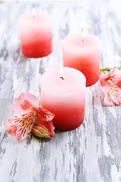 Hermosas velas con flores sobre fondo de madera — Foto de Stock