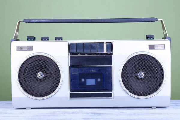 Retro cassette stereo recorder on table on green background