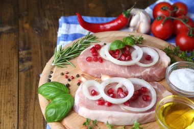 Otlar ve baharatlar ahşap arka plan üzerinde kesme tahtası üzerinde çiğ et biftek