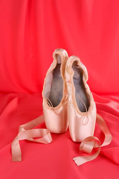 Ballet pointe schoenen op rode stof achtergrond — Stockfoto