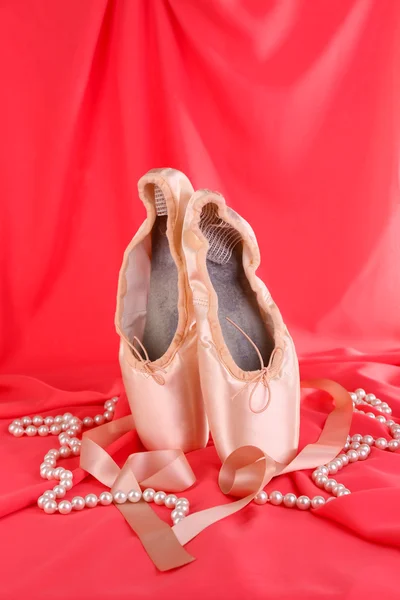 Zapatillas de punto de ballet sobre fondo de tela roja — Foto de Stock