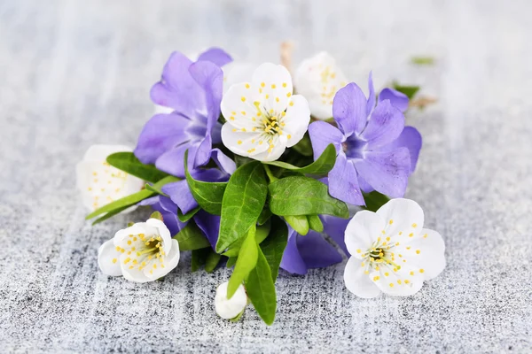 Hermoso ramo con flores de periwinkle en la mesa de madera —  Fotos de Stock