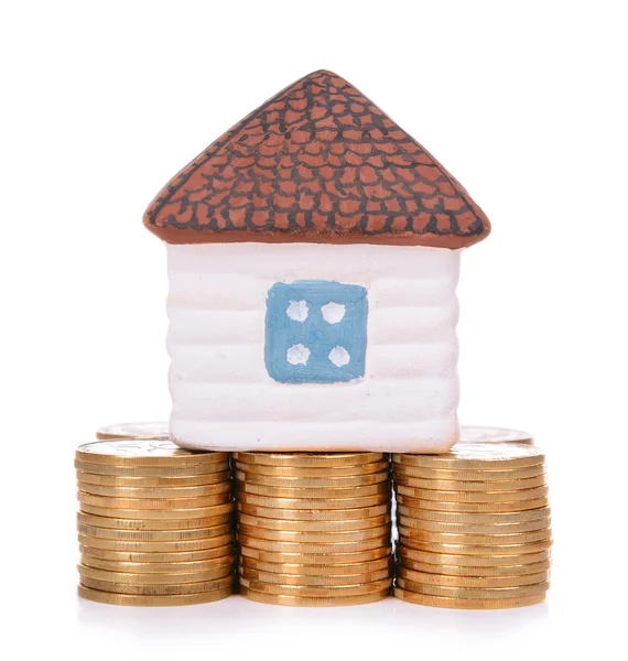 House standing on heap of coins isolated on white — Stock Photo, Image