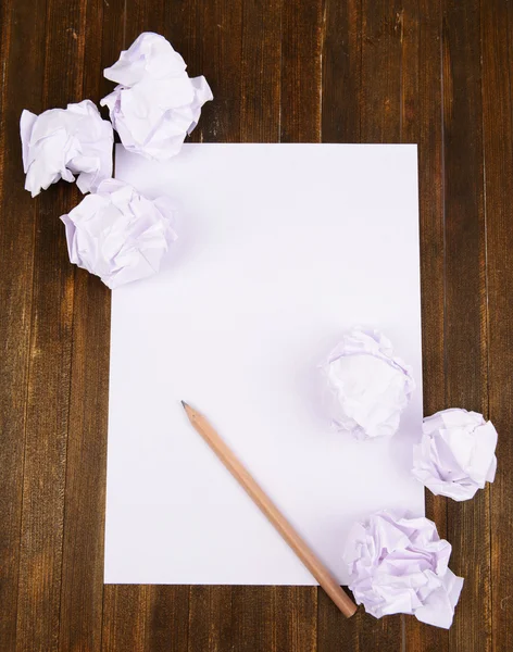 Hoja de papel blanco con papel arrugado y lápiz en primer plano de la mesa — Foto de Stock