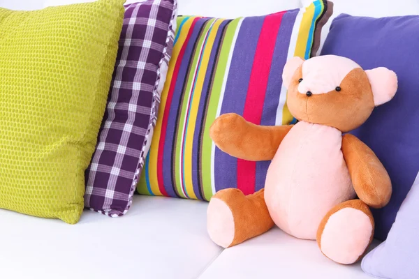 Oso de juguete con almohadas en el sofá —  Fotos de Stock