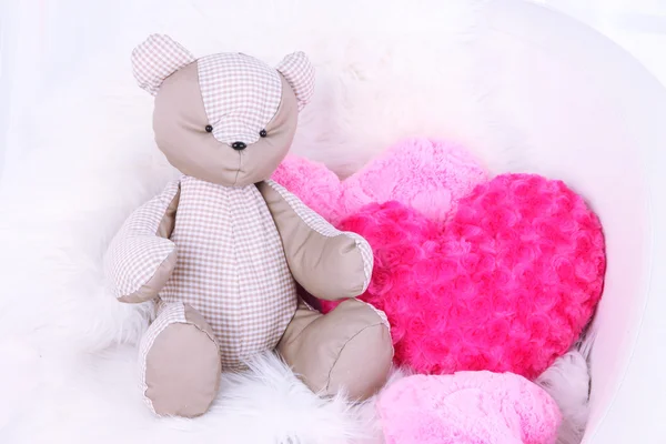 Медвежья игрушка с подушками на кресле в номере — стоковое фото