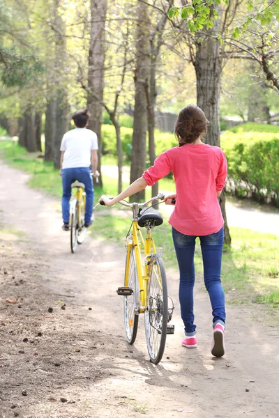 Young couple with bicycles in park — Stock Photo, Image