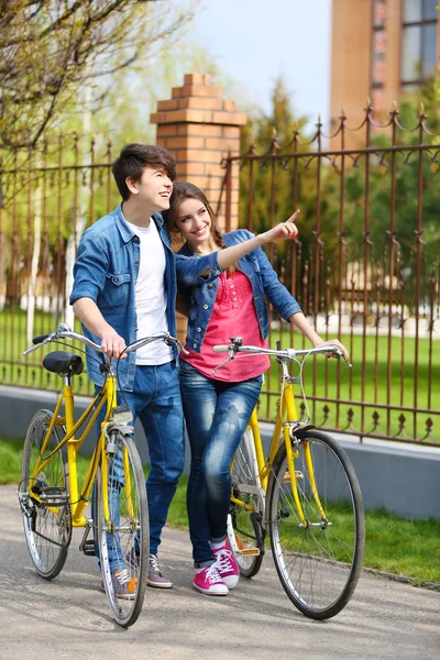 Pareja joven con bicicletas afuera — Foto de Stock