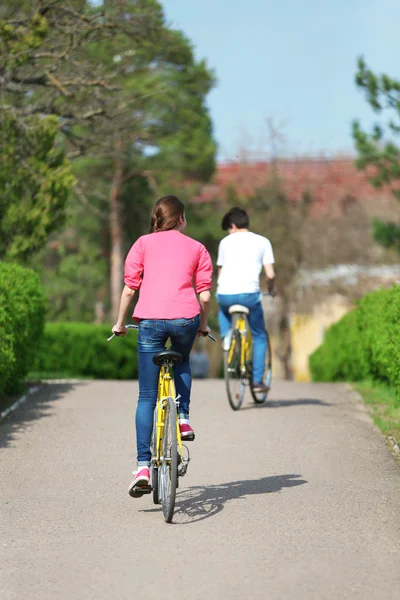 Junges Paar auf Fahrrädern im Park unterwegs — Stockfoto