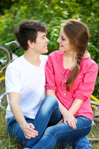 Pareja joven sentada en el parque — Foto de Stock