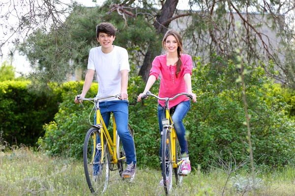 Młoda para na rowery w parku — Zdjęcie stockowe