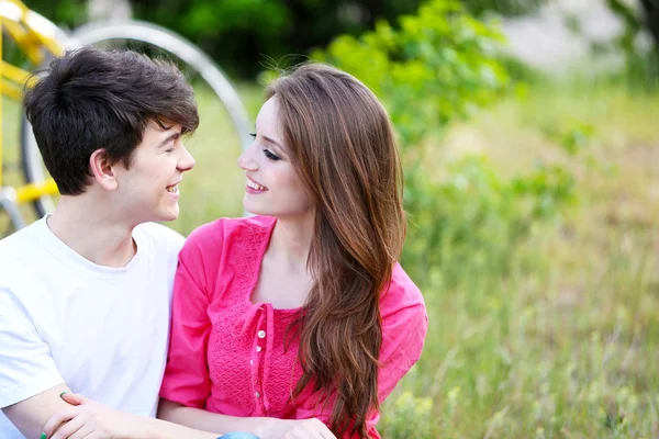 Jeune couple assis dans le parc — Photo