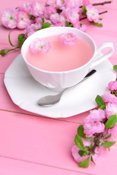 Beautiful fruit blossom with cup of tea on table close-up — Stock Photo, Image