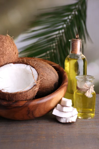 Cocos e óleo de coco sobre mesa de madeira — Fotografia de Stock