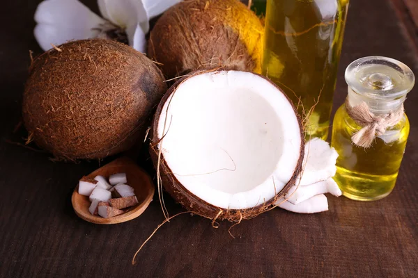 Cocos y aceite de coco sobre mesa de madera — Foto de Stock