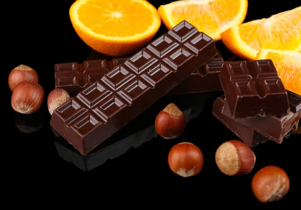 Czekolada, pomarańczowy i orzechy laskowe na czarnym tle — Zdjęcie stockowe