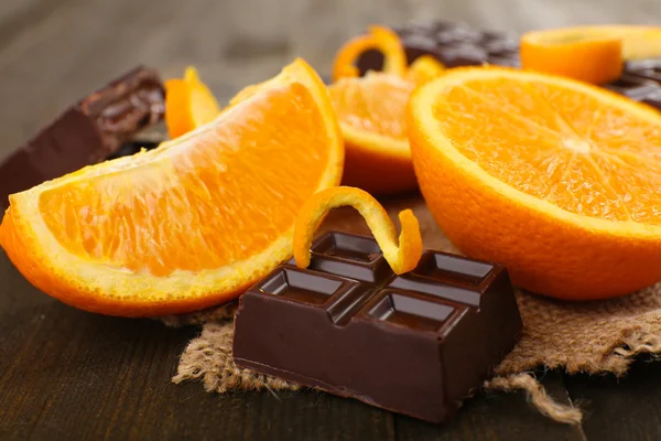 Czekolada i pomarańcza na drewnianym stole — Zdjęcie stockowe