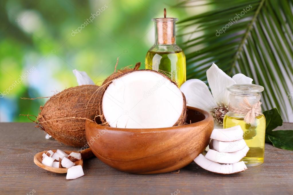 Coconuts and coconut oil on wooden table, on nature background — Stock