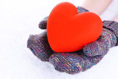 kadın ellerinde eldivenler ile kalp kar zemin üzerine