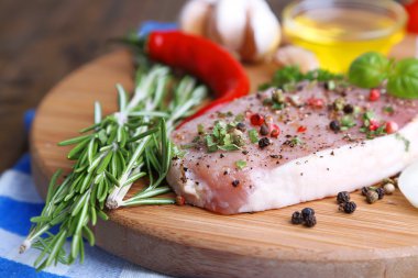 Otlar ve baharatlar ahşap arka plan üzerinde kesme tahtası üzerinde çiğ et biftek