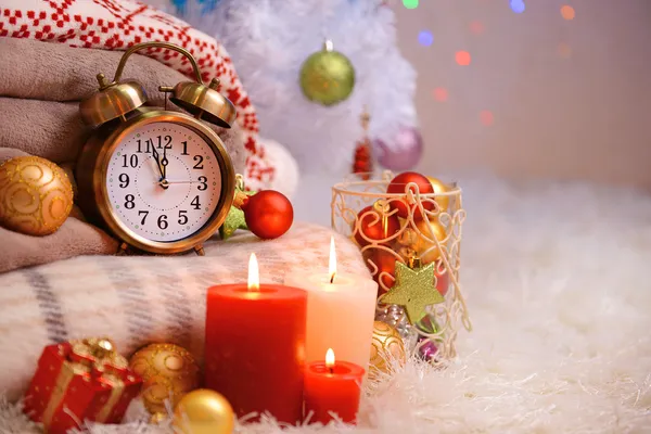 Composition avec plaids, bougies et décorations de Noël, sur tapis blanc sur fond lumineux — Photo